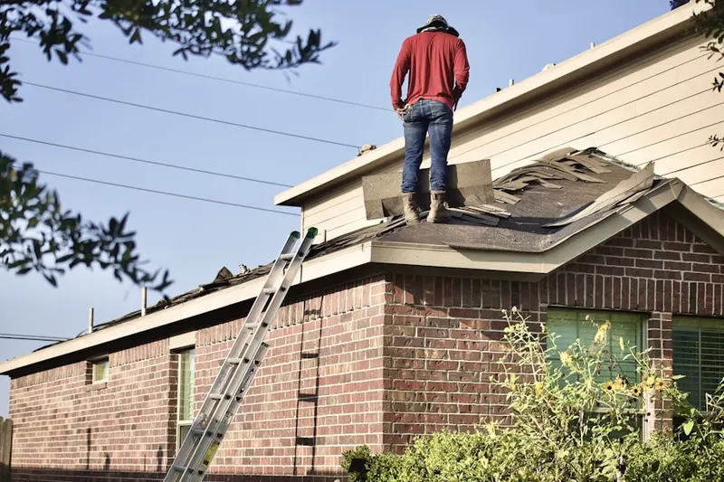 Professional roofer working on a residential roof in Iron City
